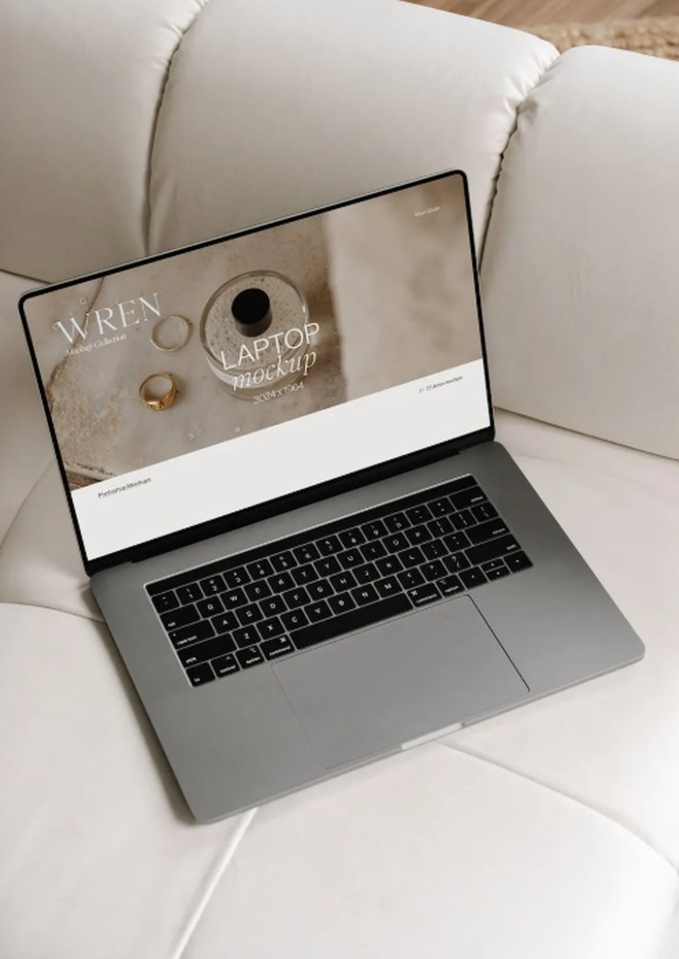 A laptop on a cream sofa showing the four M31Factory libraries scrolling